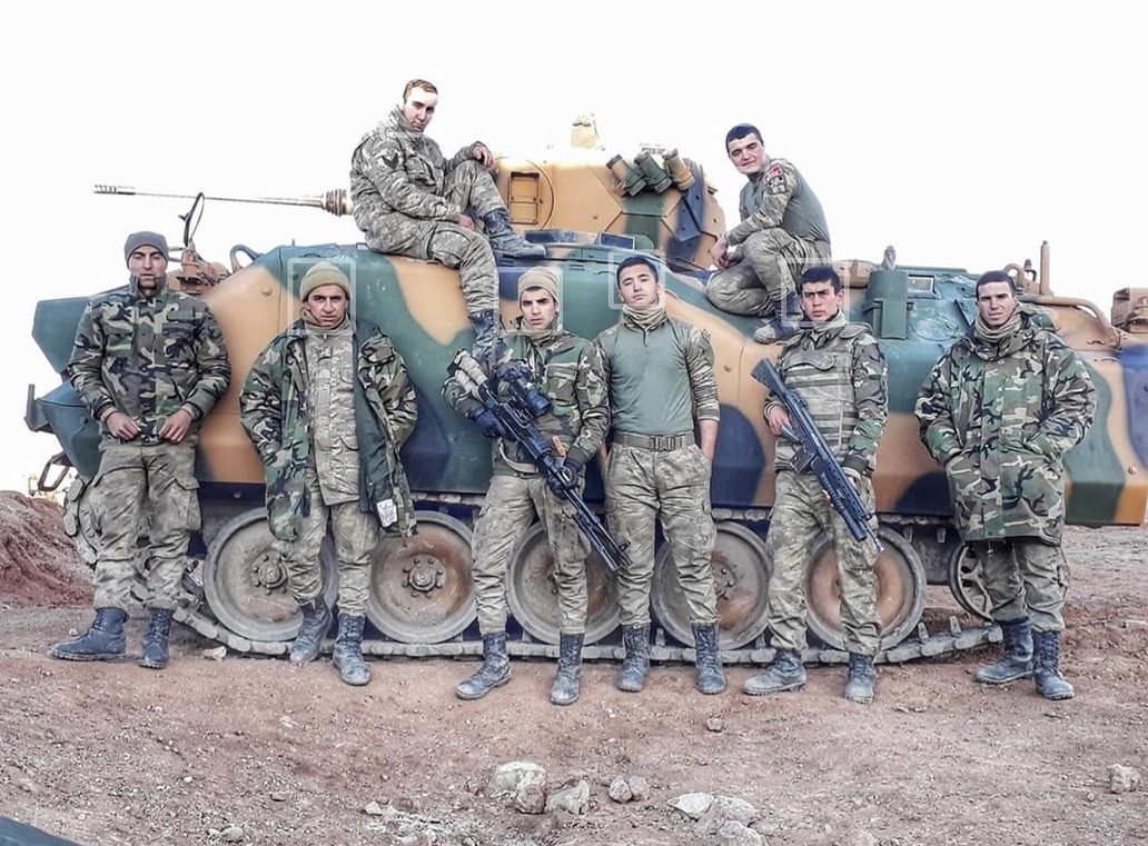 Birlik arkadaşlarıyla zırhlı aracın önünde